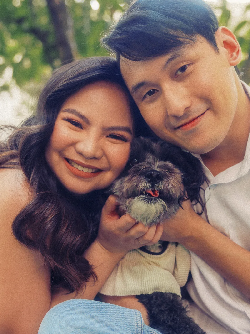 Elaine and James cheek to cheek, holding their dog