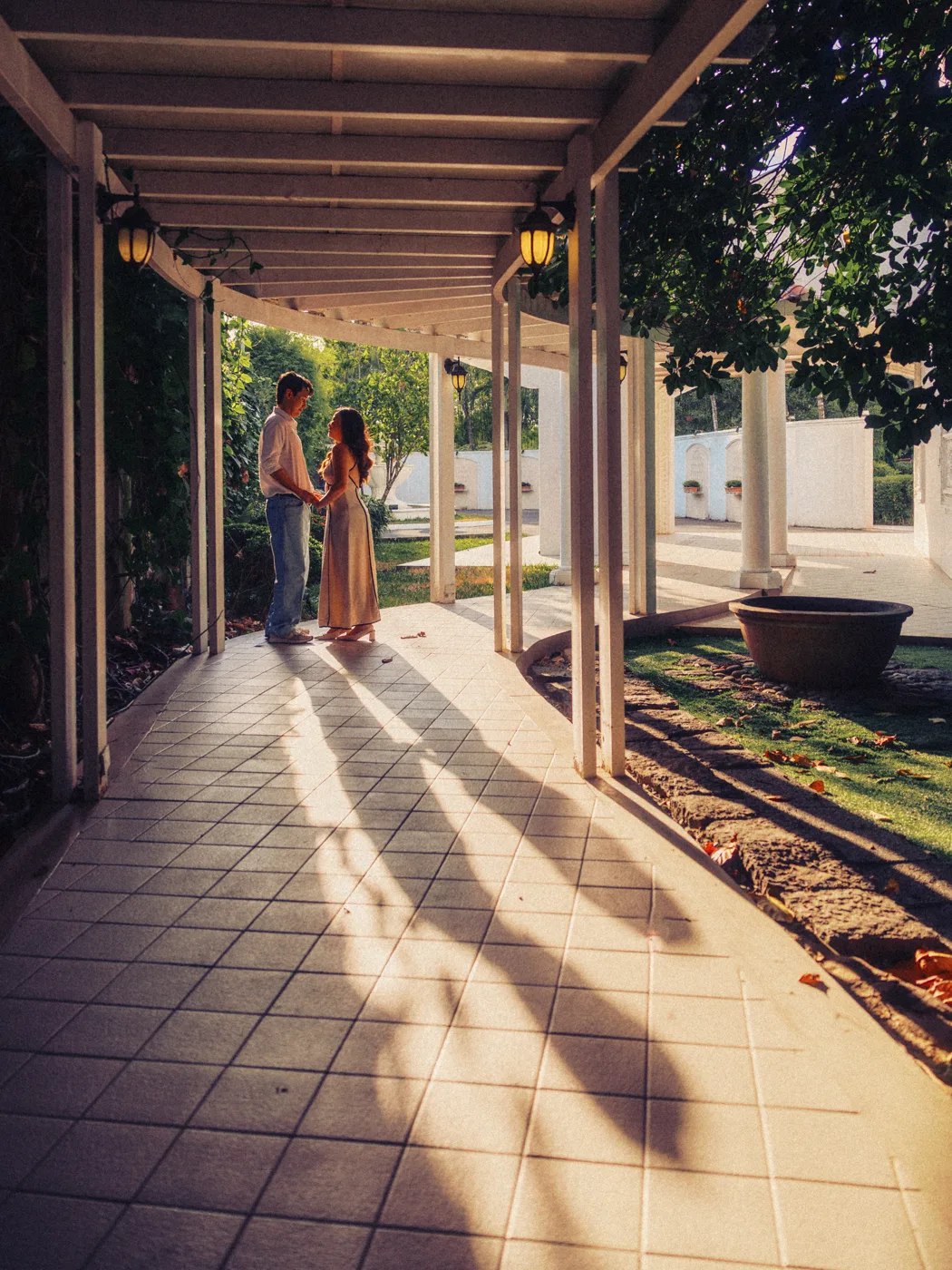 The two of them standing in golden light between the colonnade pillars
